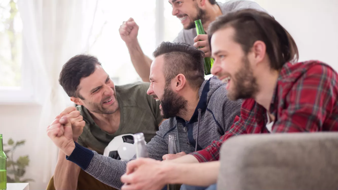 grupo de amigos assistindo futebol