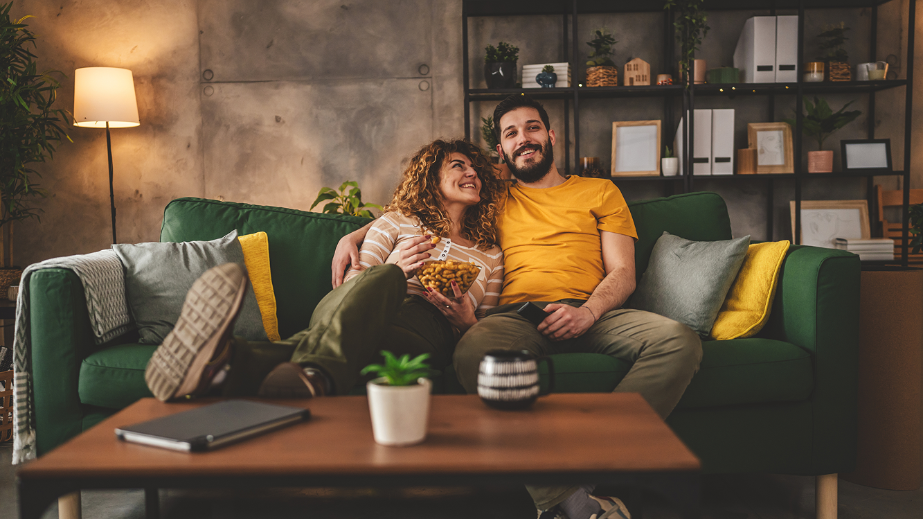 Homem e mulher assistem TV na sala